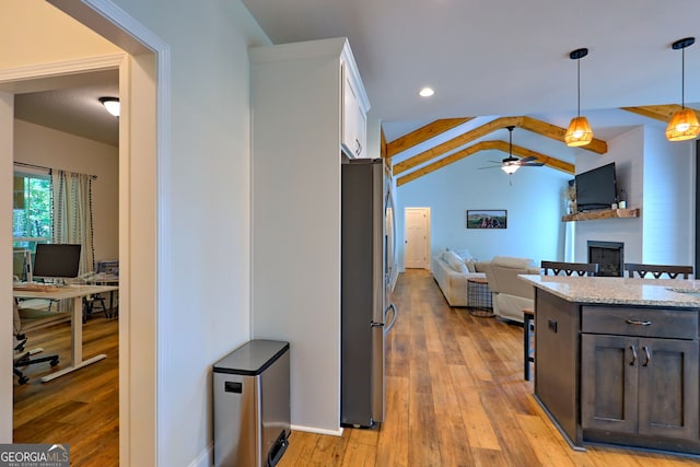 kitchen with dark brown cabinets, light wood-type flooring, white cabinetry, and stainless steel fridge