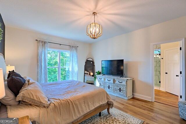 bedroom featuring light hardwood / wood-style flooring and a chandelier