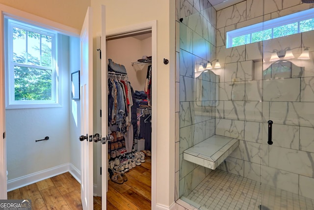 bathroom with hardwood / wood-style flooring and a shower with shower door