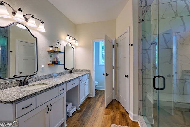 bathroom featuring toilet, a shower with door, vanity, and wood-type flooring