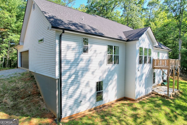 view of property exterior with a garage and a lawn