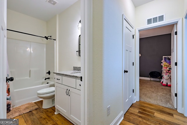 full bathroom featuring toilet, wood-type flooring, vanity, and tub / shower combination