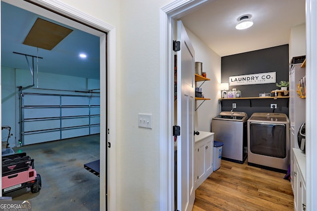 clothes washing area featuring washer and dryer and hardwood / wood-style flooring