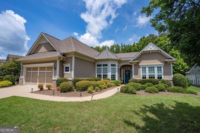 craftsman inspired home featuring a garage and a front lawn