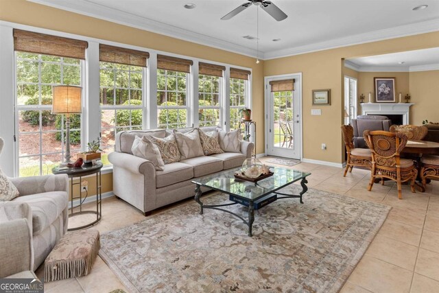 living room with ceiling fan, light tile patterned floors, and crown molding