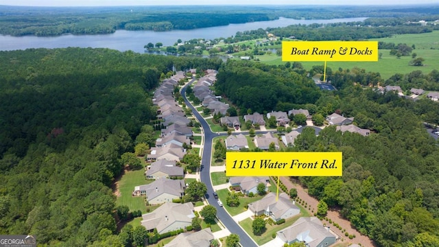 birds eye view of property featuring a water view, a residential view, and a view of trees