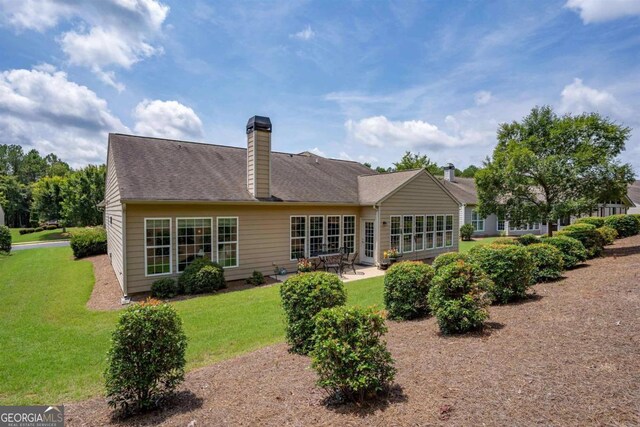 back of house with a patio area and a yard