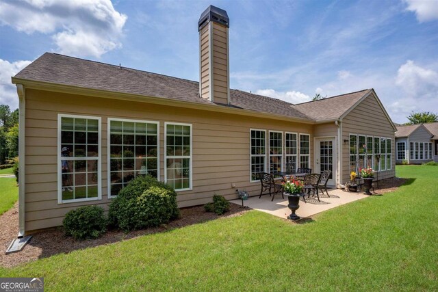 back of property featuring a yard and a patio