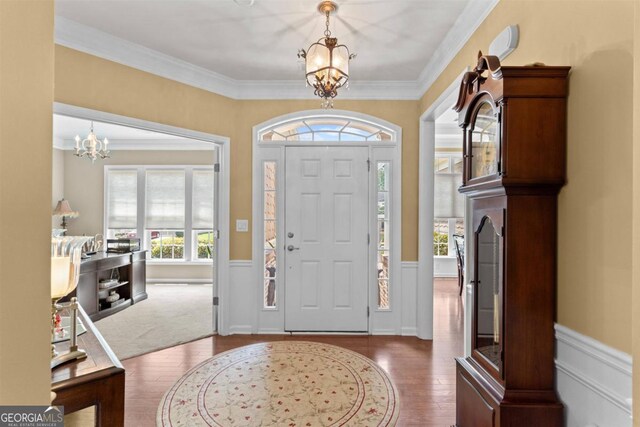 entrance foyer featuring hardwood / wood-style flooring, a notable chandelier, and ornamental molding