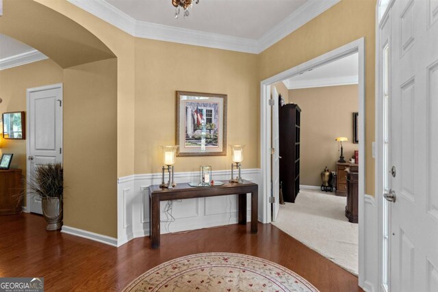 carpeted entrance foyer with crown molding