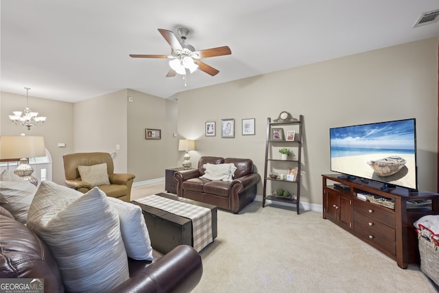 carpeted living room with ceiling fan with notable chandelier