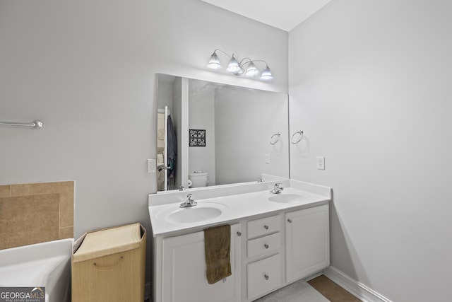 bathroom with toilet and double vanity