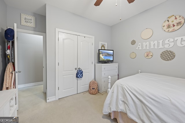 bedroom featuring ceiling fan, a closet, and light colored carpet