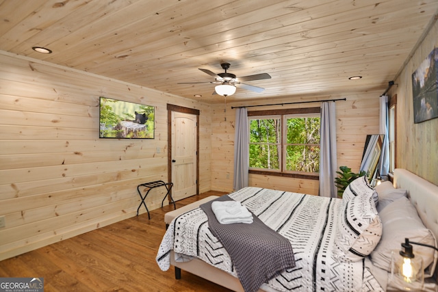 bedroom with hardwood / wood-style flooring, ceiling fan, wooden walls, and wood ceiling