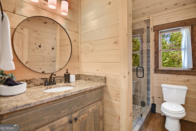 bathroom with wood walls, vanity, wood-type flooring, toilet, and walk in shower