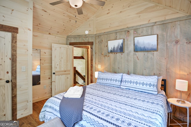 bedroom with ceiling fan, hardwood / wood-style flooring, wooden walls, and lofted ceiling