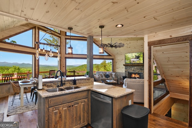 kitchen featuring a stone fireplace, wood-type flooring, wooden ceiling, dishwasher, and hanging light fixtures