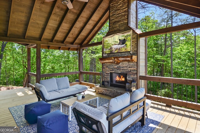 sunroom featuring vaulted ceiling with beams, an outdoor stone fireplace, and wooden ceiling