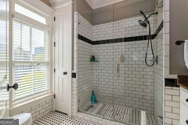 bathroom with an enclosed shower, a healthy amount of sunlight, and toilet