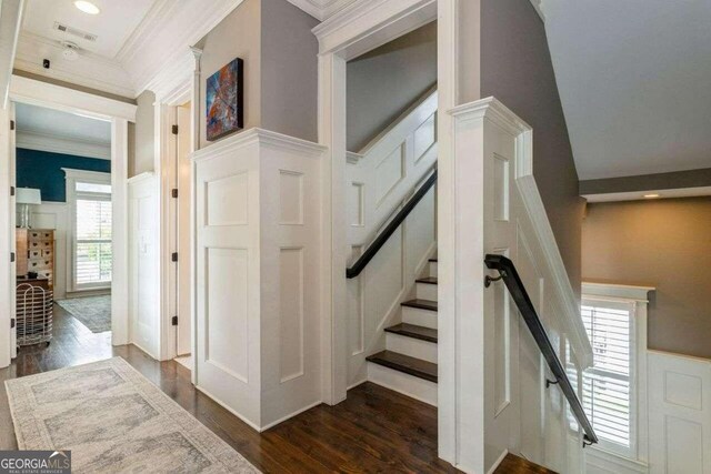 stairway featuring ornamental molding and wood-type flooring