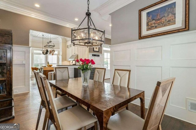 dining area with ornamental molding, a healthy amount of sunlight, dark hardwood / wood-style flooring, and a chandelier