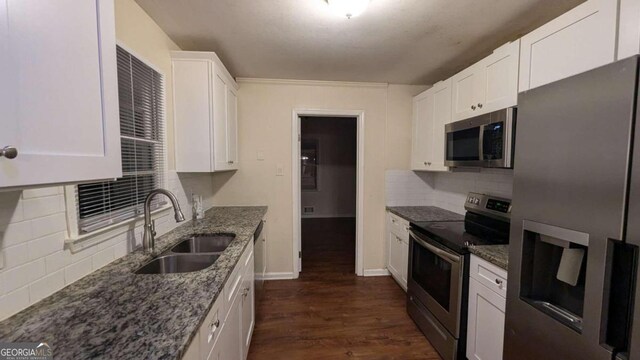 kitchen with stainless steel appliances, dark hardwood / wood-style floors, tasteful backsplash, sink, and white cabinets