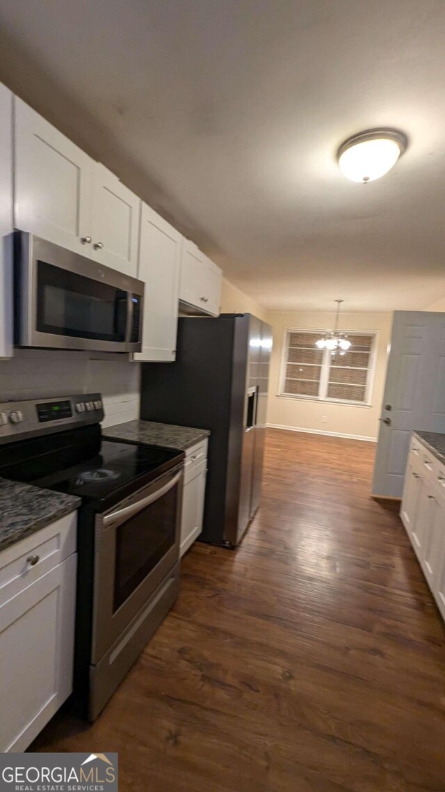 kitchen with a chandelier, stainless steel appliances, dark wood-type flooring, and white cabinets