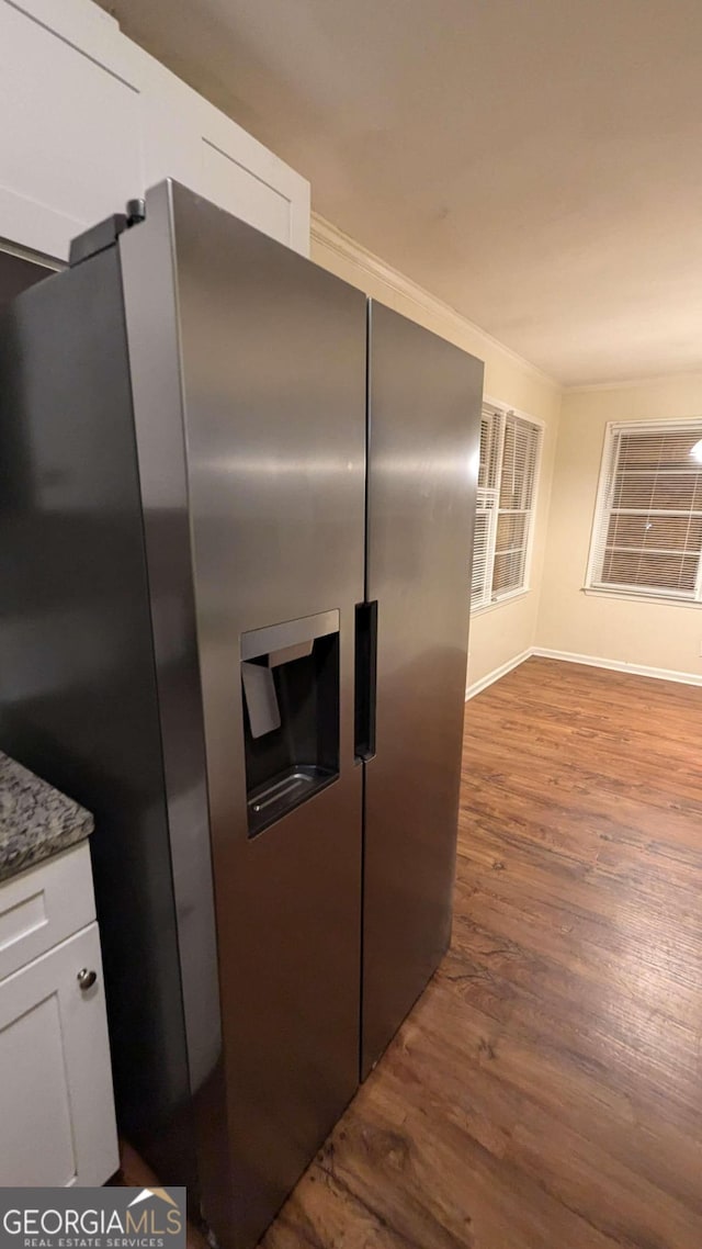 kitchen featuring white cabinetry, stone countertops, hardwood / wood-style flooring, and stainless steel fridge