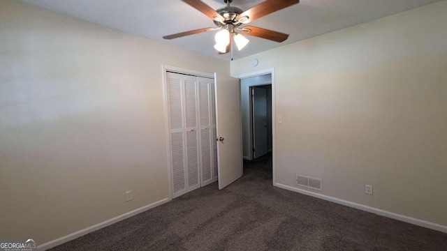 unfurnished bedroom with ceiling fan, a closet, and dark carpet