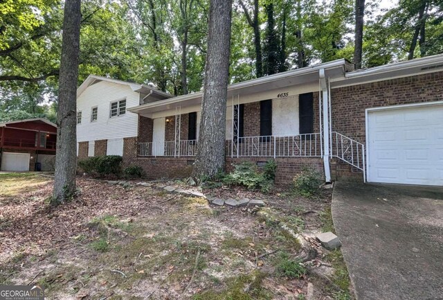 tri-level home featuring covered porch and a garage