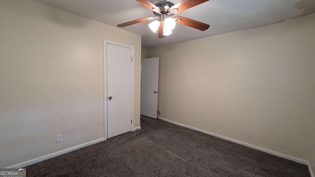 unfurnished room featuring ceiling fan and dark carpet