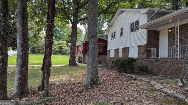 view of side of home with a yard