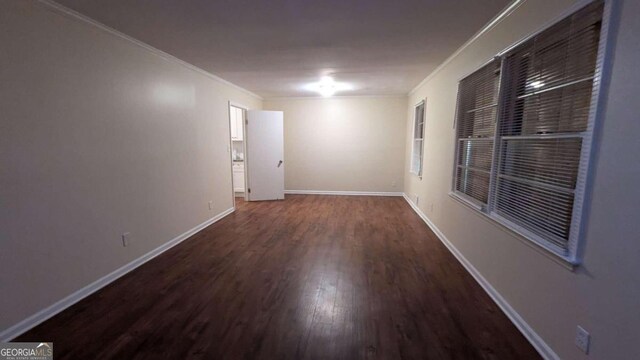 spare room with crown molding and dark hardwood / wood-style flooring