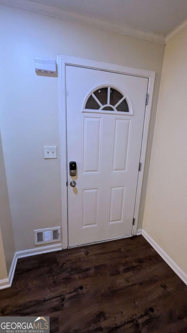 foyer entrance with crown molding and dark wood-type flooring