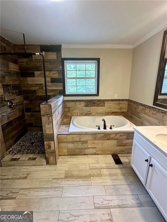 bathroom with ornamental molding, separate shower and tub, and vanity