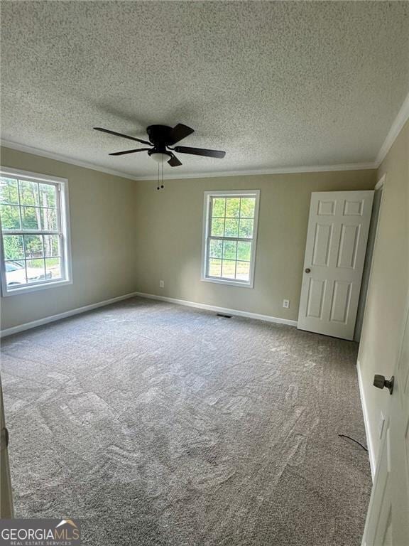 carpeted empty room featuring ceiling fan, a textured ceiling, and crown molding