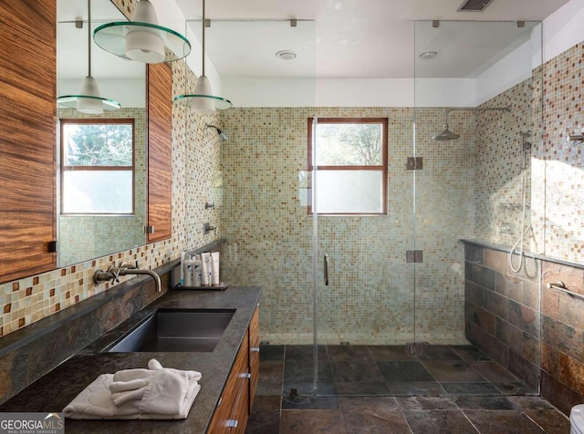 bathroom with vanity, plenty of natural light, an enclosed shower, and decorative backsplash