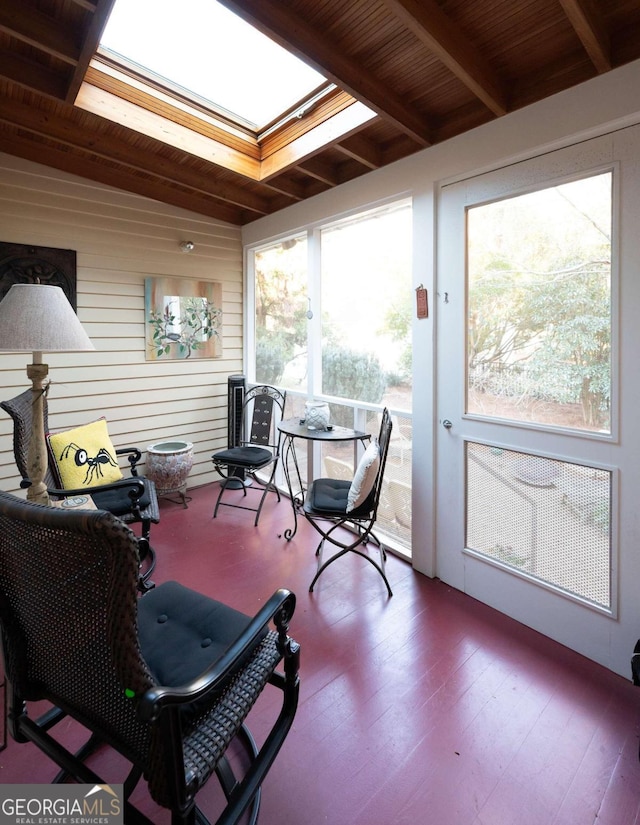 sunroom / solarium featuring a skylight, wood ceiling, and beam ceiling