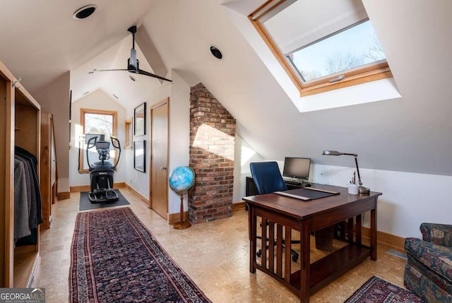 office space with vaulted ceiling with skylight