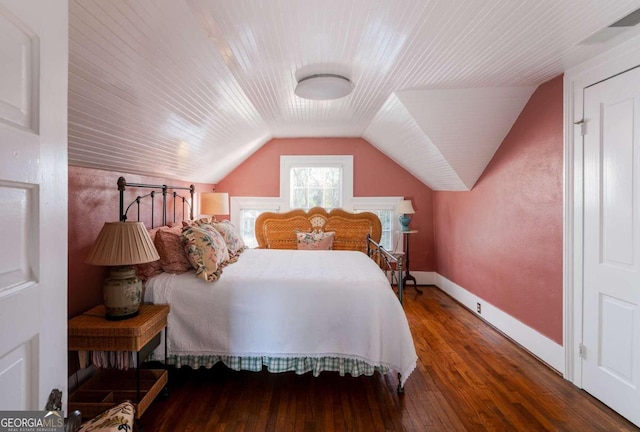 bedroom with vaulted ceiling and dark wood-type flooring