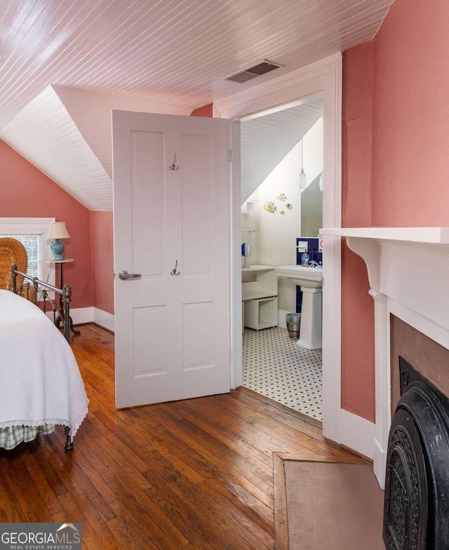 bedroom with vaulted ceiling and hardwood / wood-style floors