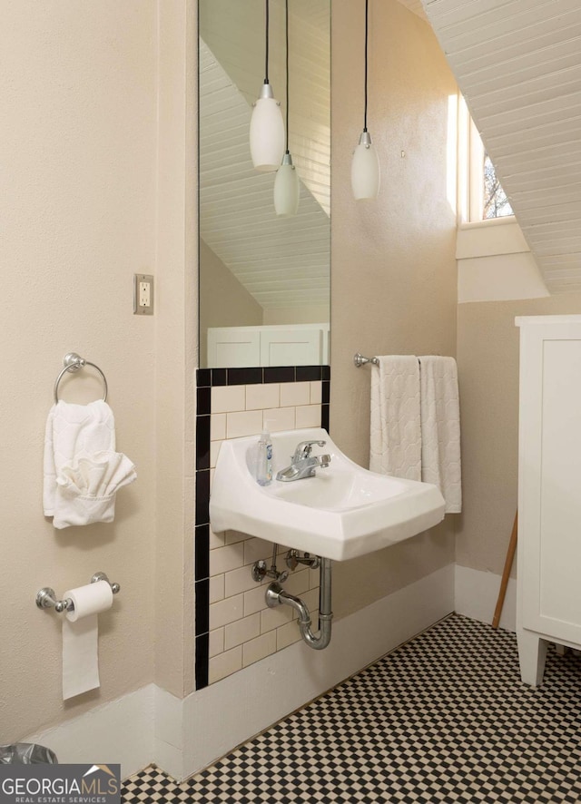 bathroom with lofted ceiling and sink