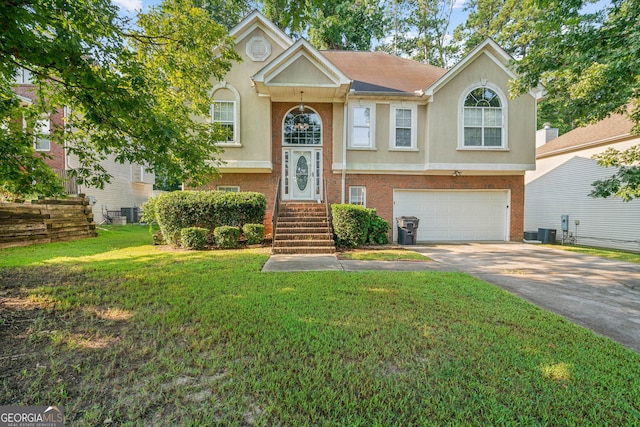 bi-level home featuring a garage, central air condition unit, and a front yard