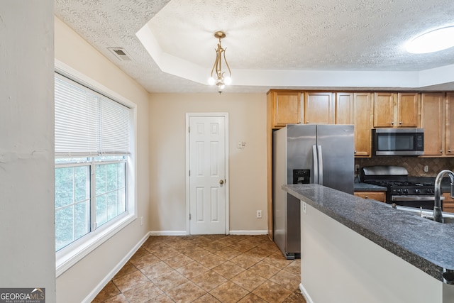 kitchen with backsplash, decorative light fixtures, appliances with stainless steel finishes, light tile patterned floors, and a raised ceiling