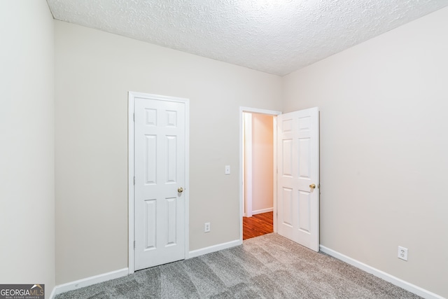 unfurnished bedroom featuring a textured ceiling and carpet flooring