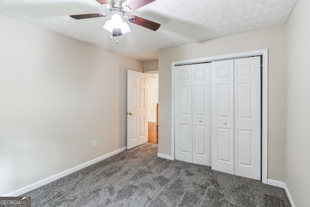 unfurnished bedroom featuring ceiling fan, a closet, a textured ceiling, and carpet floors