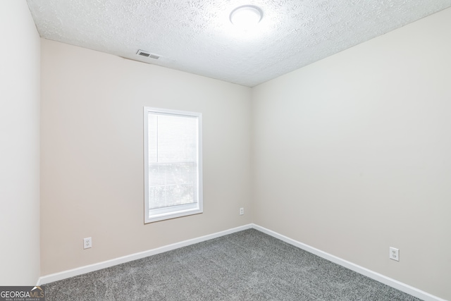 carpeted spare room featuring a textured ceiling