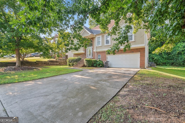 raised ranch featuring central air condition unit, a garage, and a front lawn