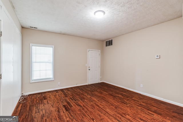 unfurnished room featuring a textured ceiling and hardwood / wood-style floors