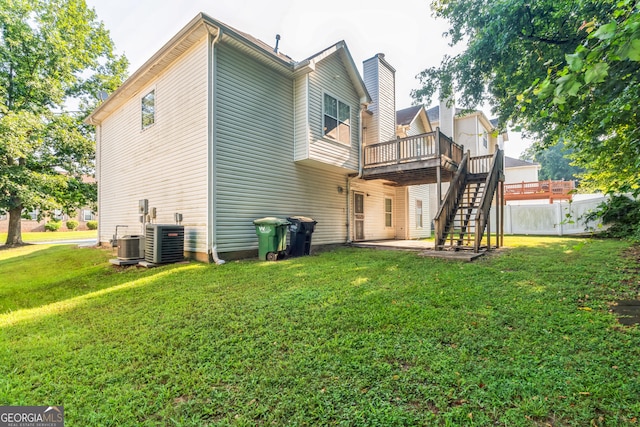 view of side of home featuring a yard, central AC, and a deck